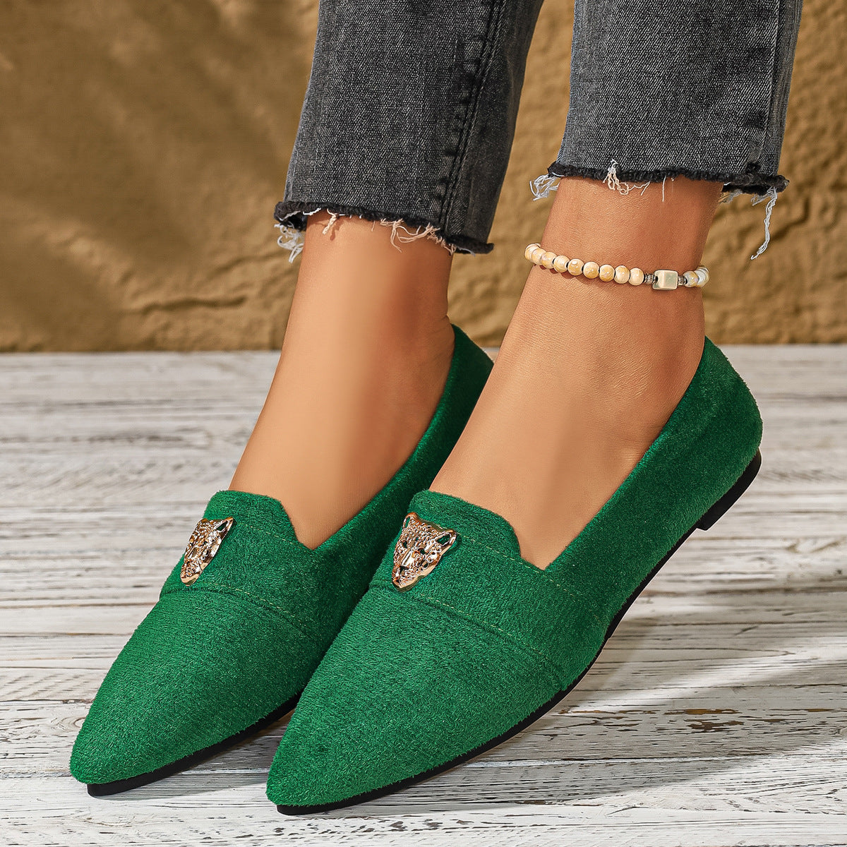 Green slip-on flats with pointed toe and animal head embellishment