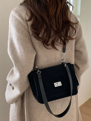Sleek black suede crossbody bag with flap closure and silver hardware.