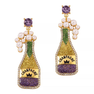 Champagne bottle dangle earrings with purple gems, pearls, and glitter.