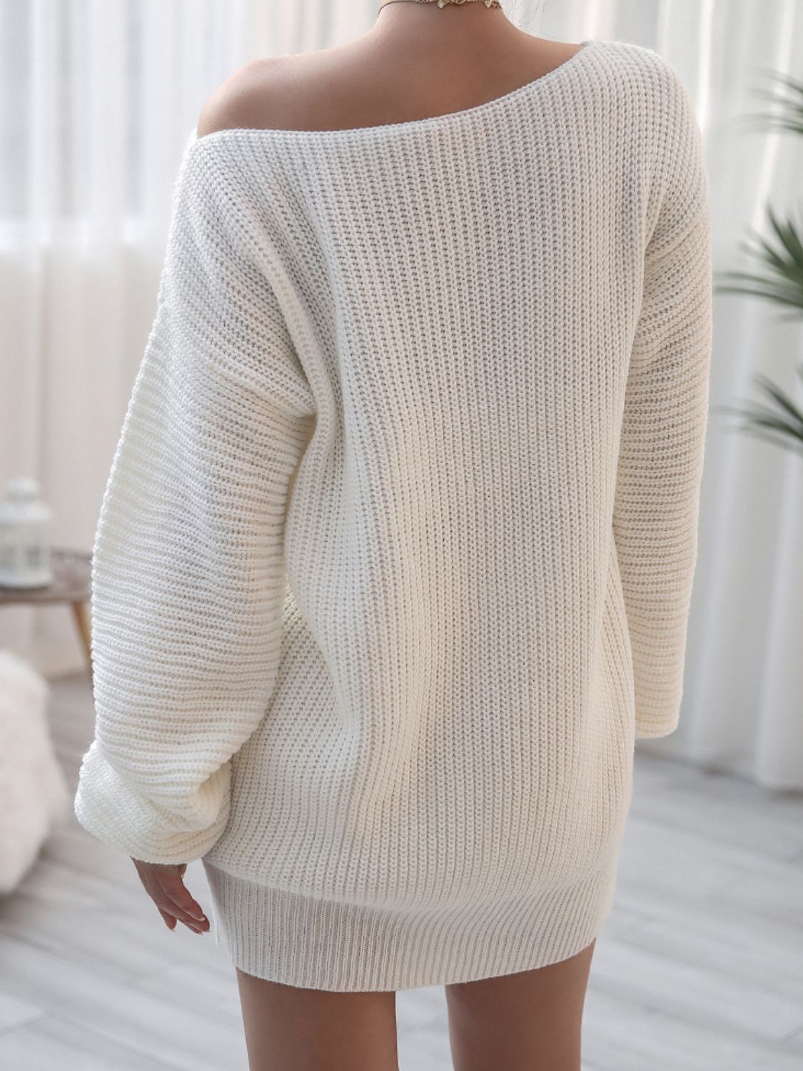 White acrylic sweater dress with balloon sleeves and off-the-shoulder neckline.