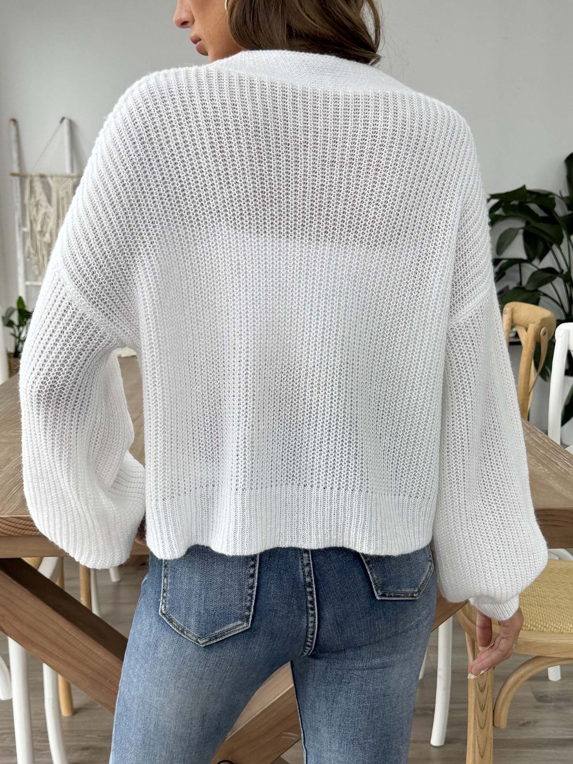 White balloon sleeve cardigan with buttoned front and textured knit.