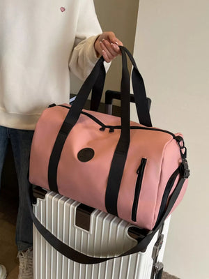 Pink travel organizer bag with black straps and zippers, adjustable shoulder strap.