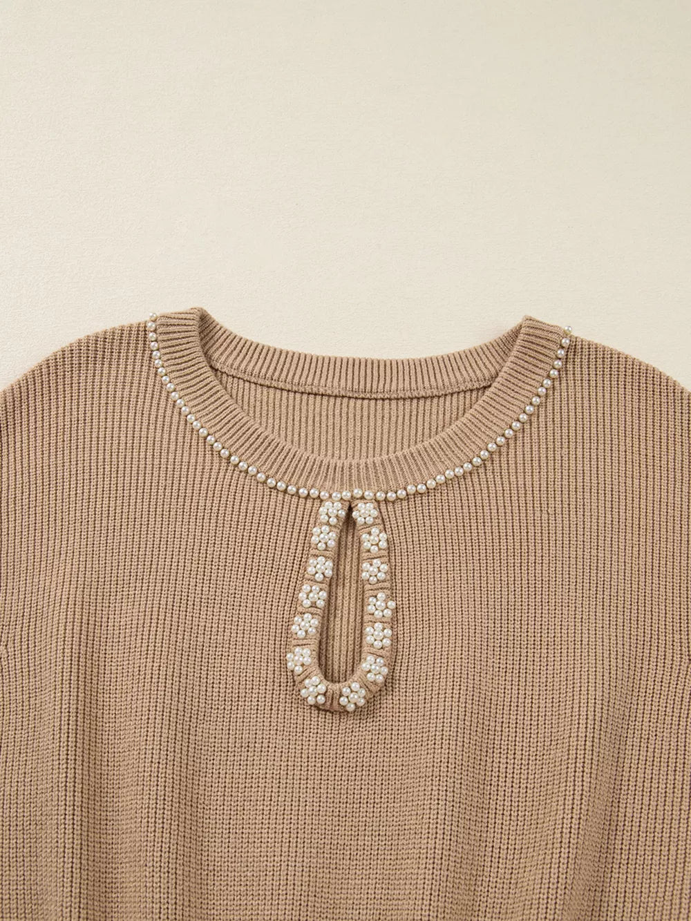 Ribbed knit sweater dress in tan with pearl-adorned keyhole neckline detail.