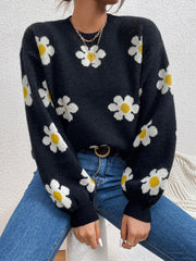 Black knit sweater with white and yellow daisy print and puff sleeves.