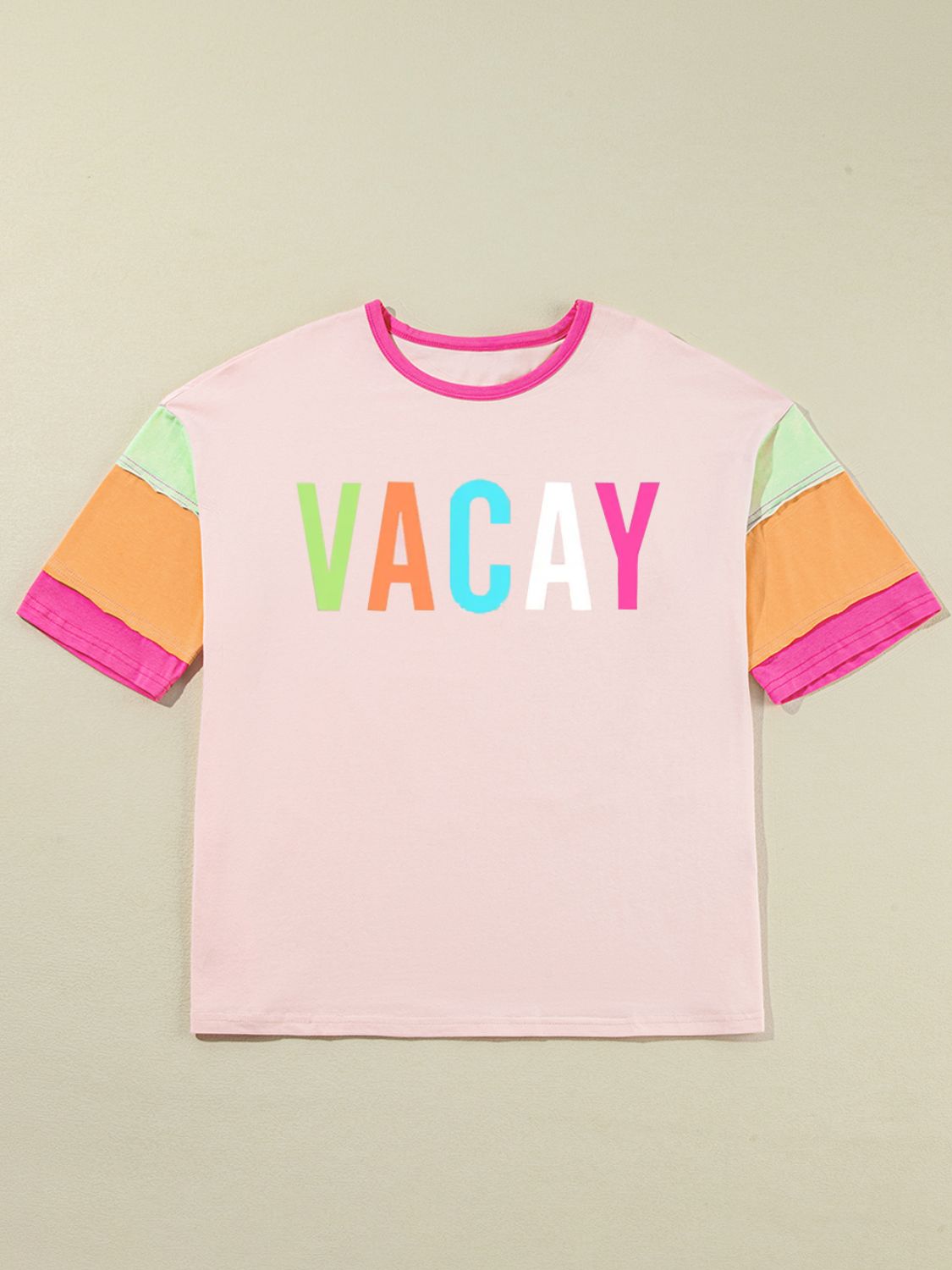 Colorblock graphic tee in pink with "VACAY" text and multi-colored sleeves.