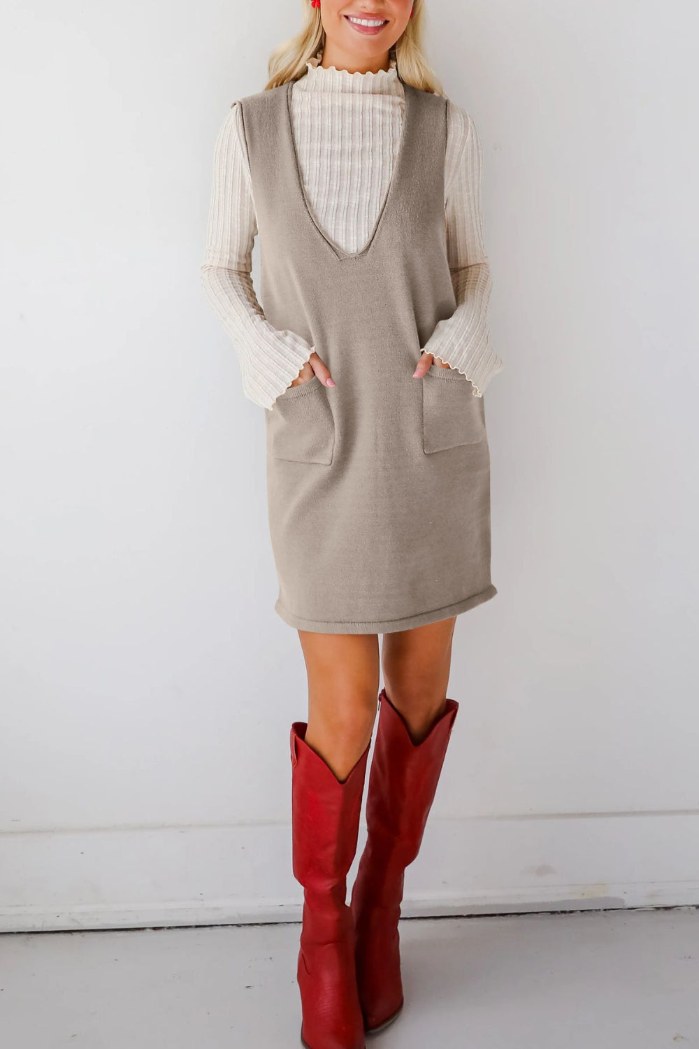 Sleeveless knit dress in gray with V-neck and two front pockets.