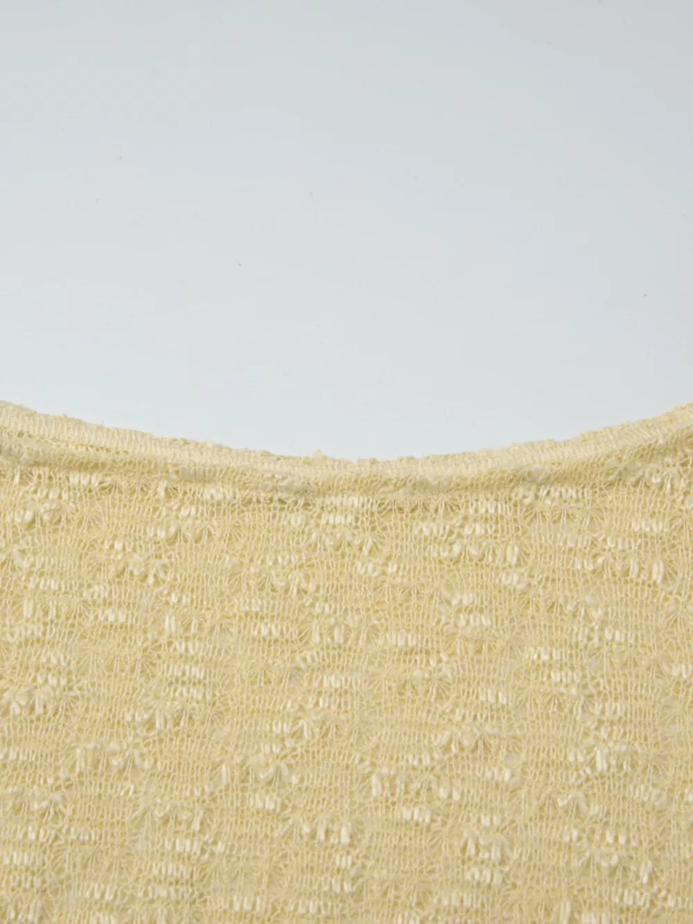 Yellow sheer one-shoulder cropped cardigan with intricate knit pattern