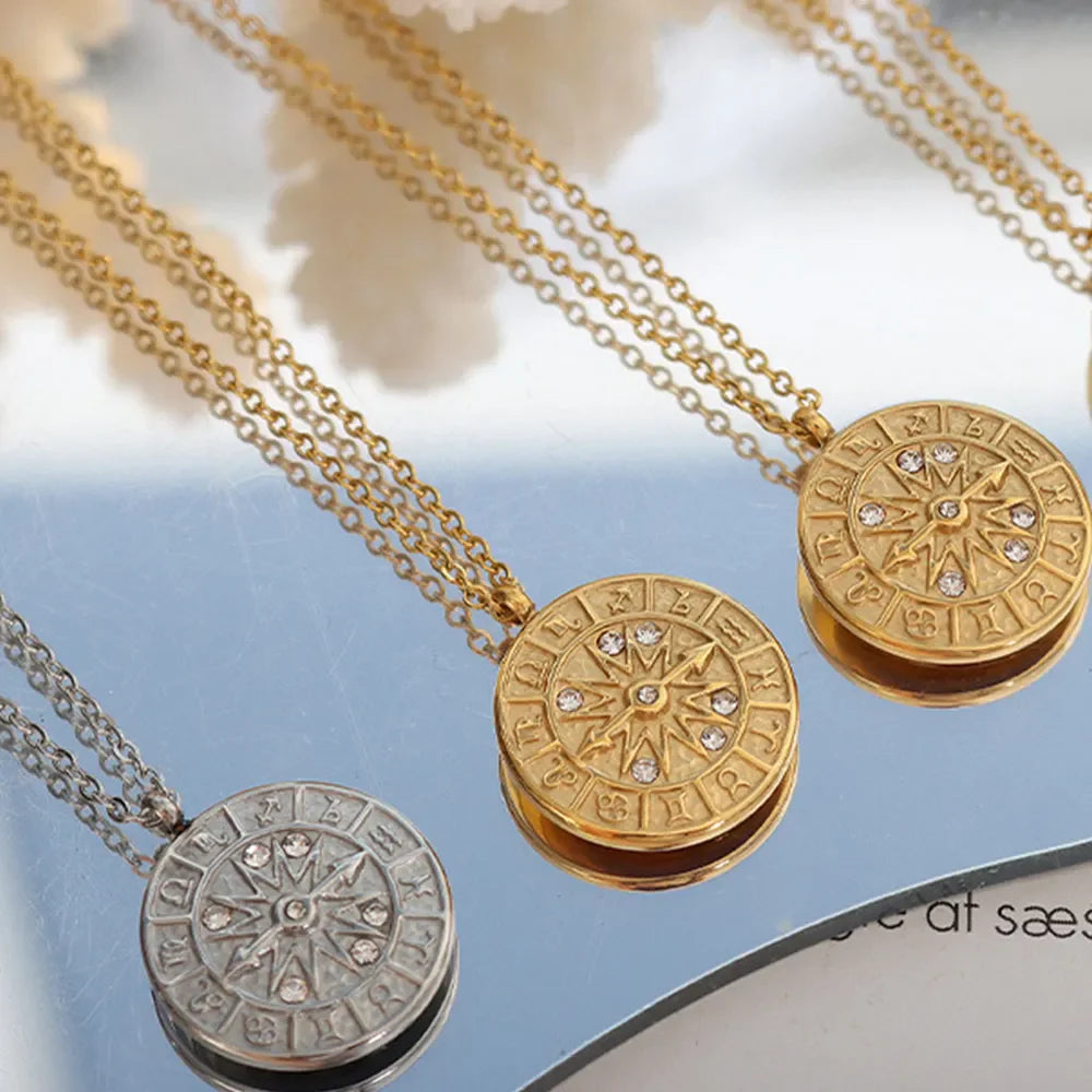 Zodiac compass pendant necklaces in gold and silver with crystal accents.