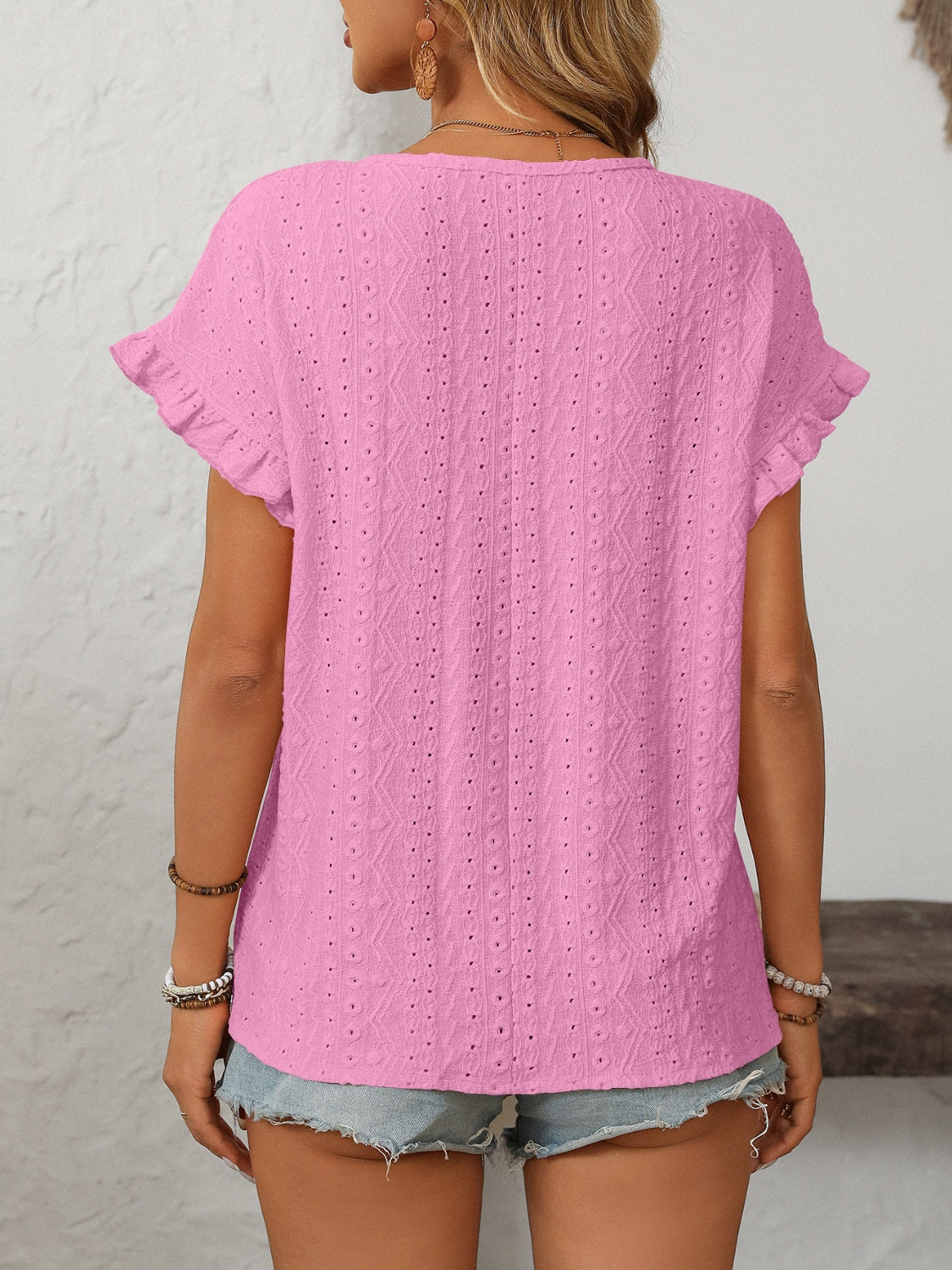 Watermelon pink eyelet knit blouse with ruffled short sleeves and a textured pattern.