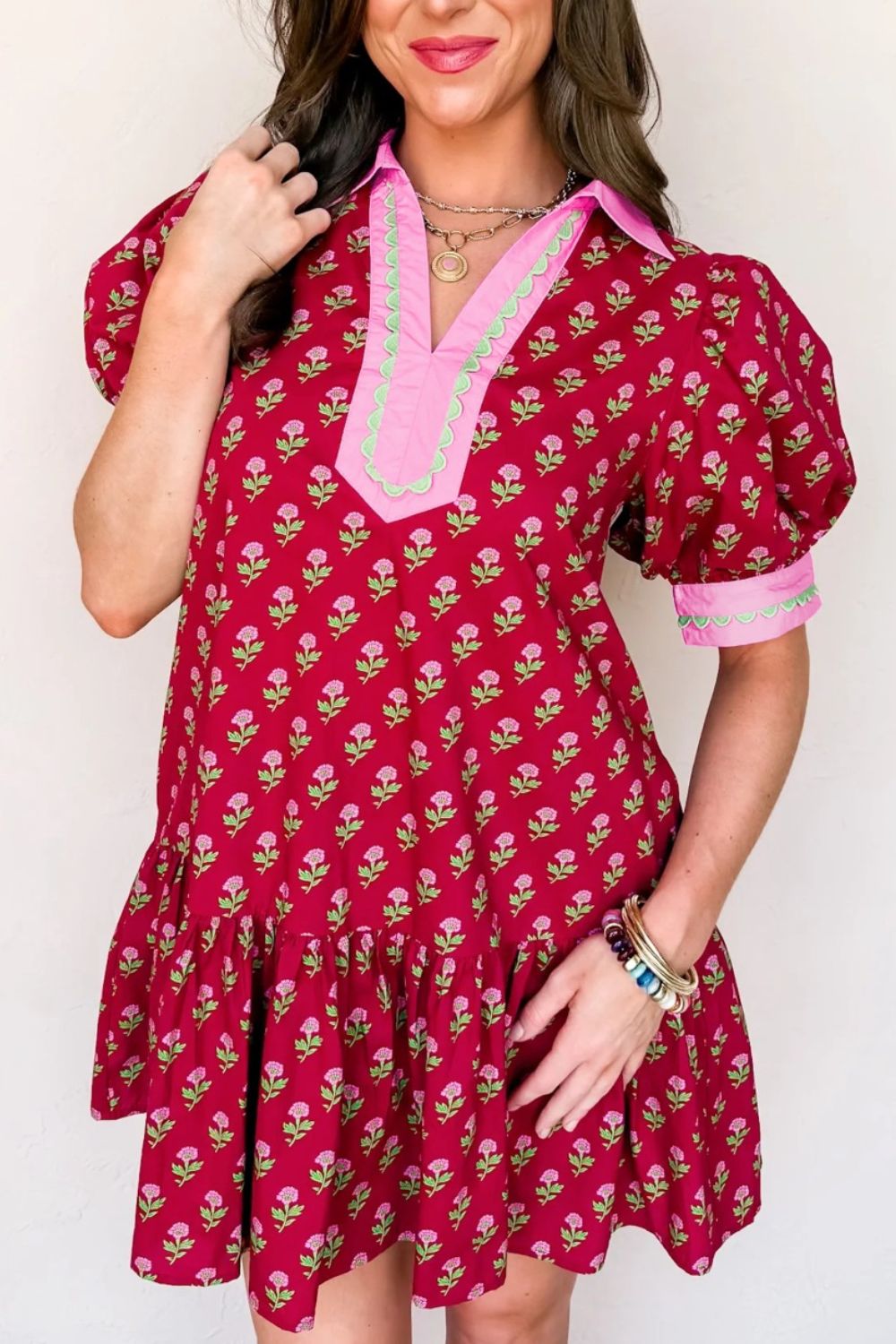Red floral mini dress with puff sleeves, ruffled hem, and contrast trim neckline.
