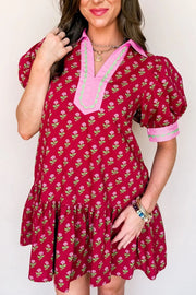Red floral mini dress with puff sleeves, ruffled hem, and contrast trim neckline.