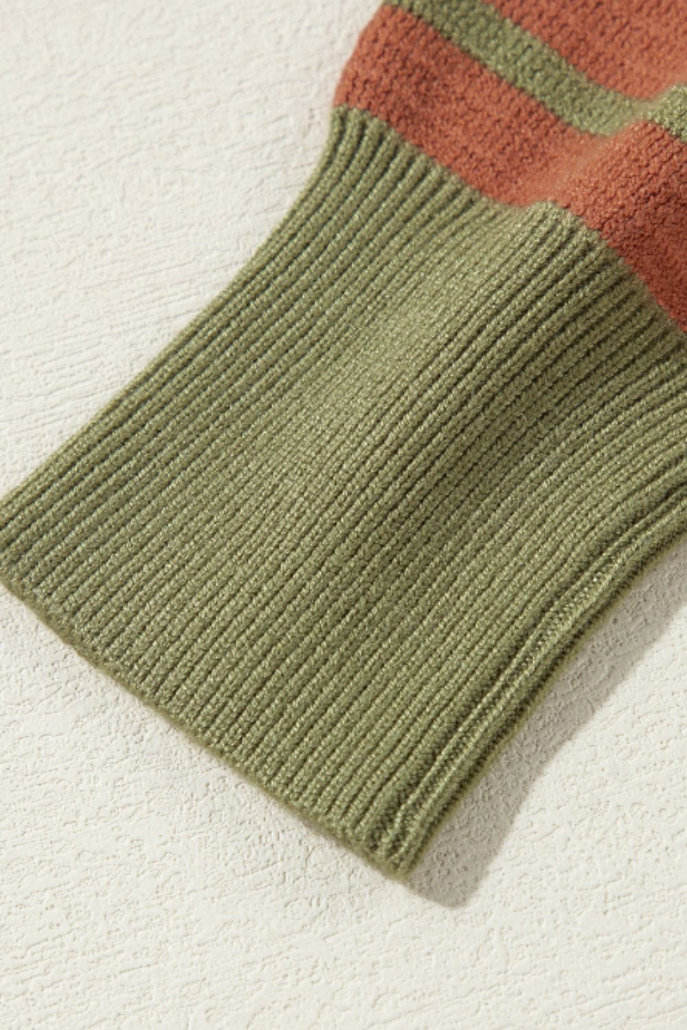 Waffle knit sweater with striped sleeve detail in brown and green.