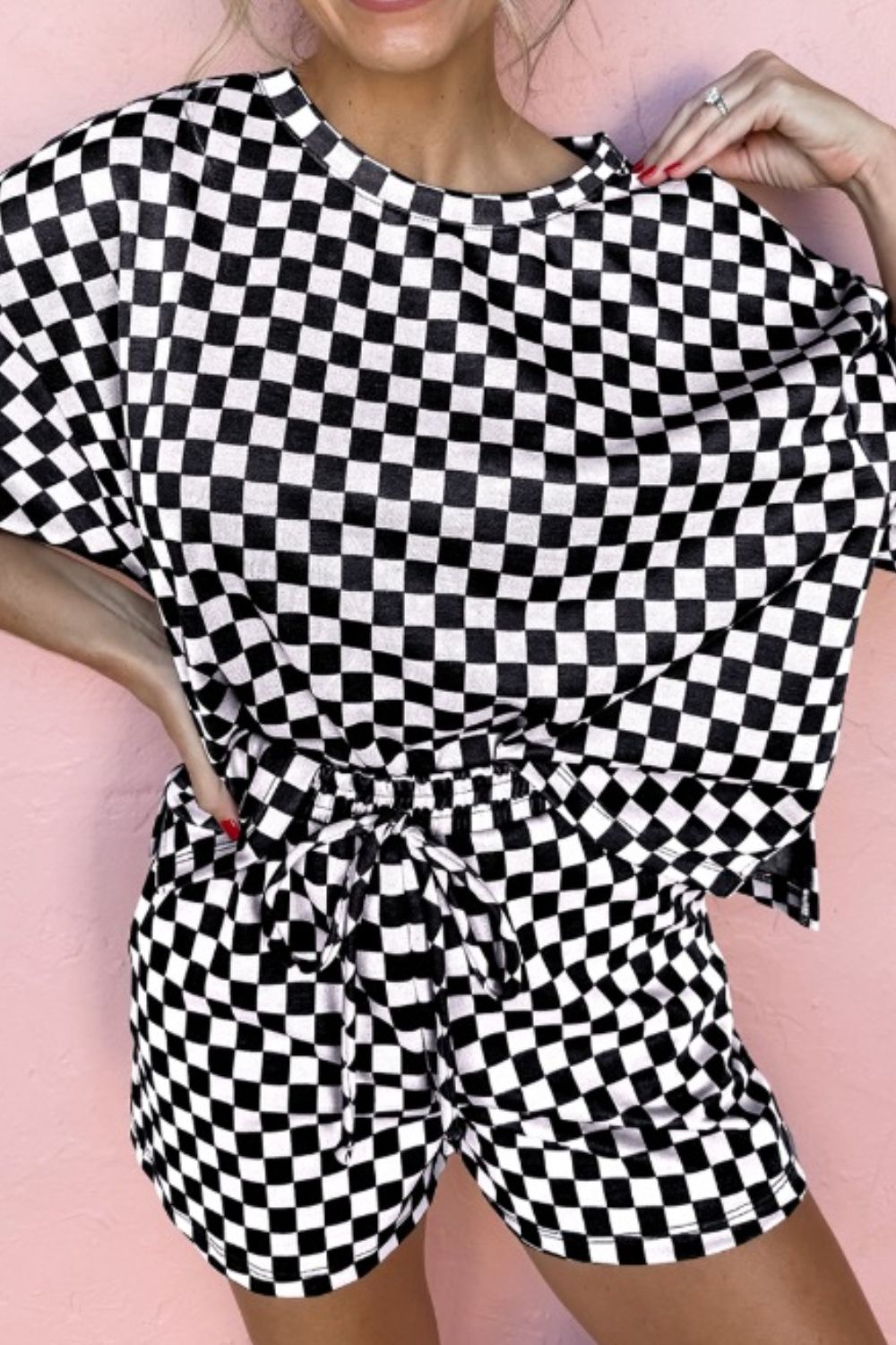Black and white checkered loungewear set with tie-waist shorts and a short-sleeve top.