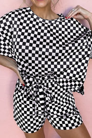 Black and white checkered loungewear set with tie-waist shorts and a short-sleeve top.