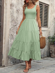 Light green smocked bodice tiered maxi dress with scoop neck and sleeveless design.