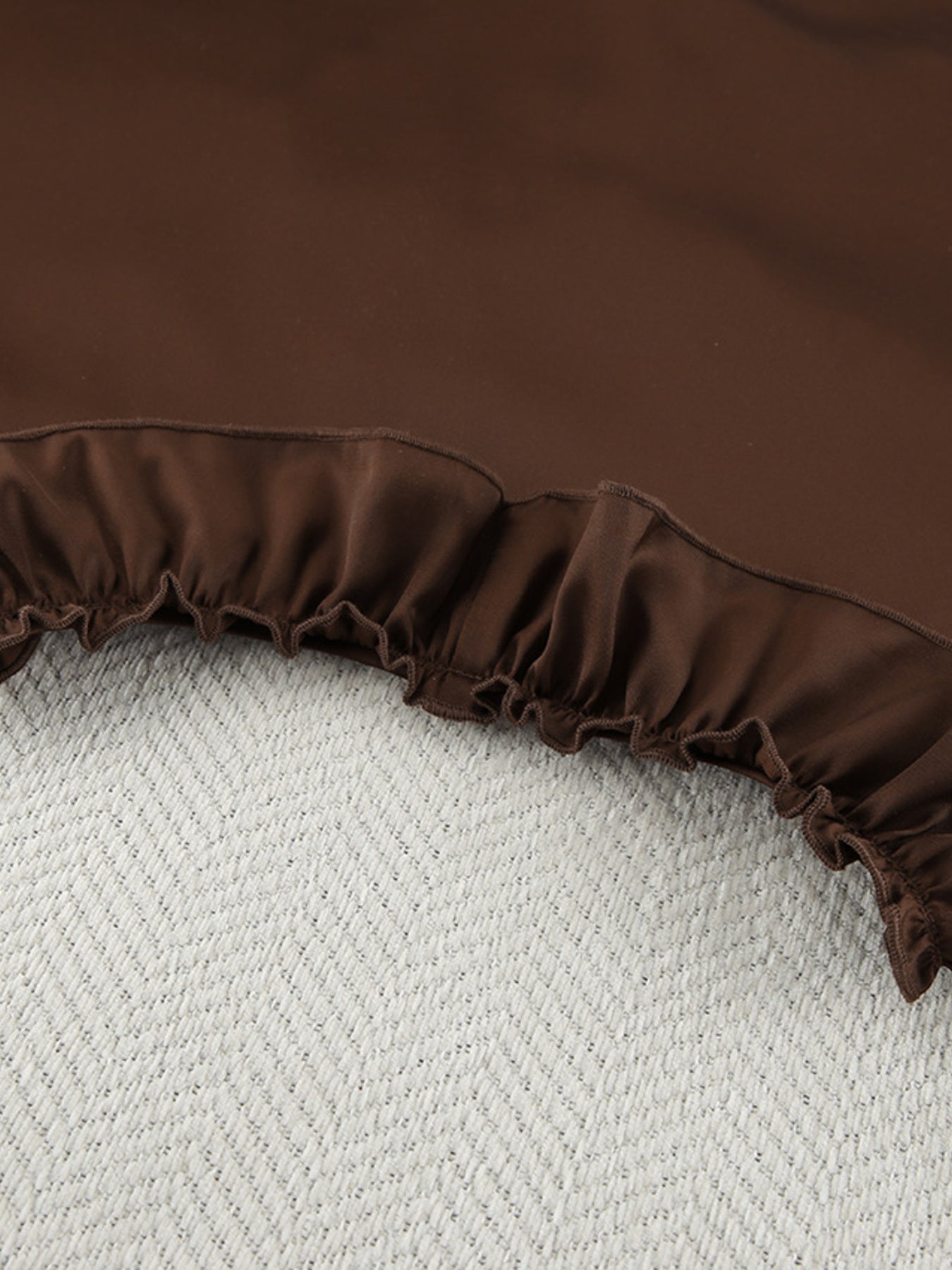 Chocolate ruffled pajama set shorts with elastic waistband and textured background.
