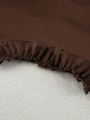 Chocolate ruffled pajama set shorts with elastic waistband and textured background.