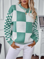 Checkerboard knit sweater in turquoise and white with a crew neck and long sleeves.