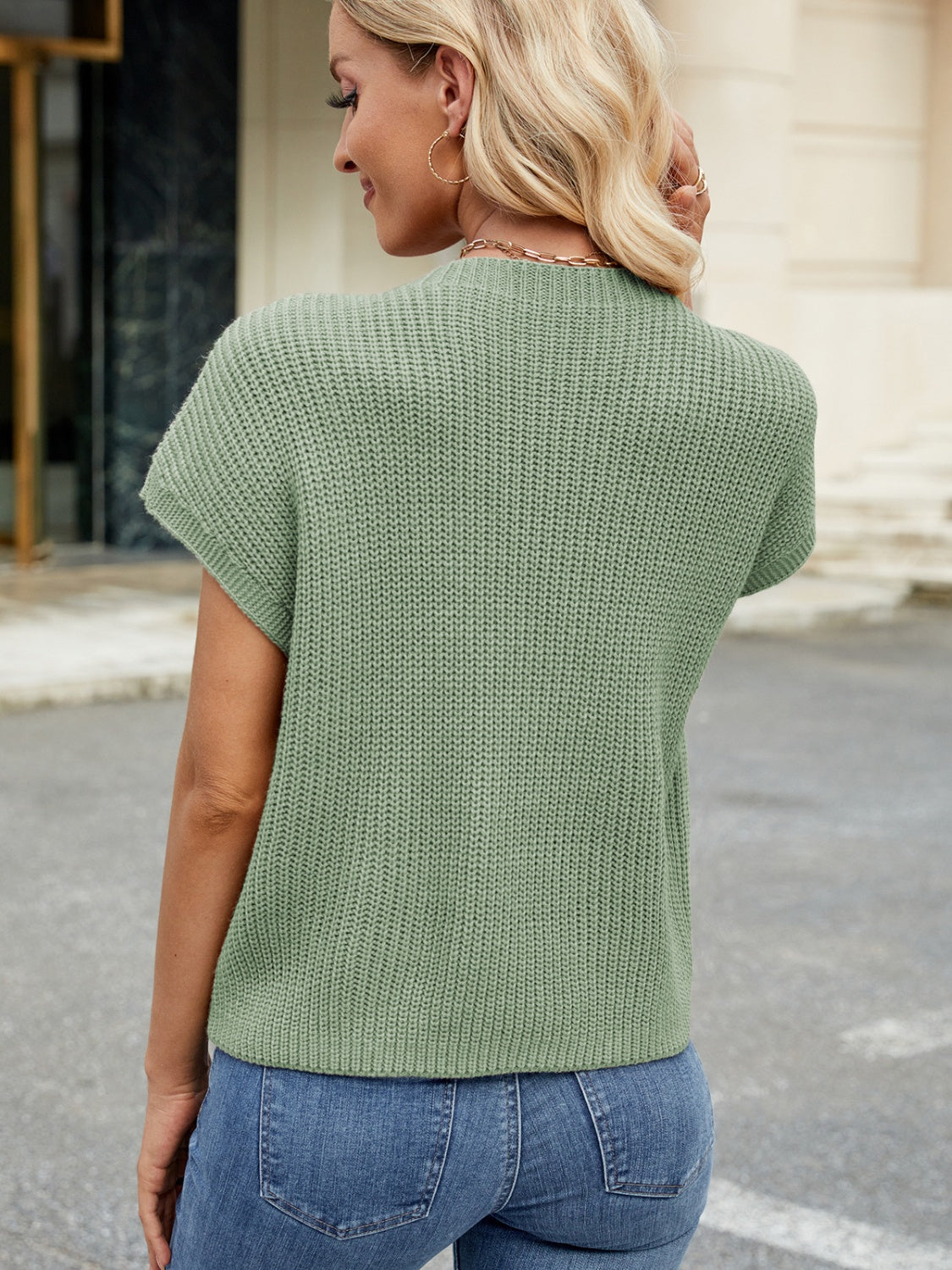 Sage green knit cap-sleeve top with ribbed texture and mock neckline.