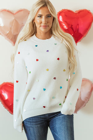 White ribbed knit sweater with multicolor heart embellishments.