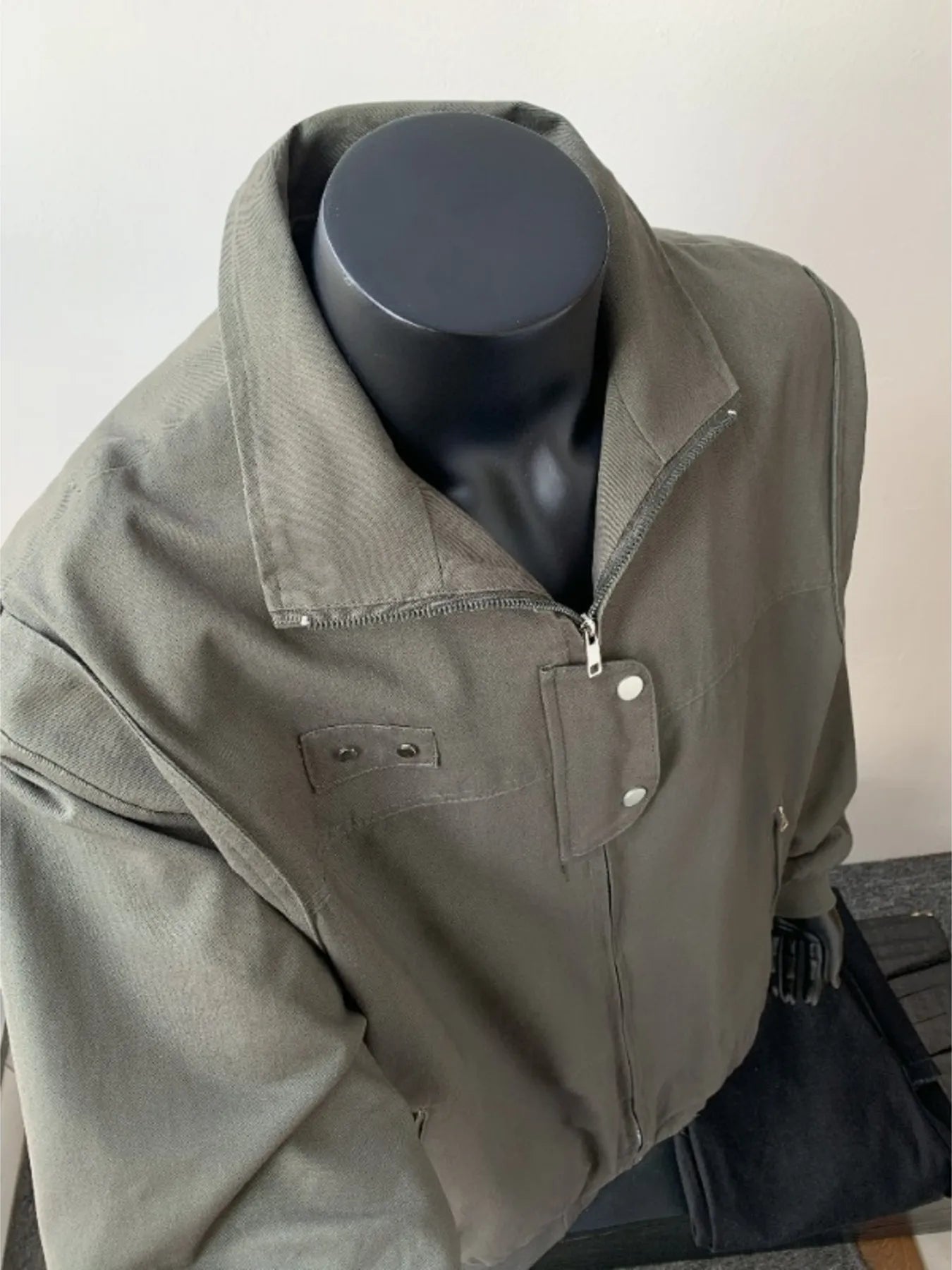 Green casual bomber jacket with zip closure and buttoned flap pockets.