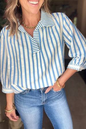 Classic blue and white striped collared blouse with textured fabric and buttoned placket.