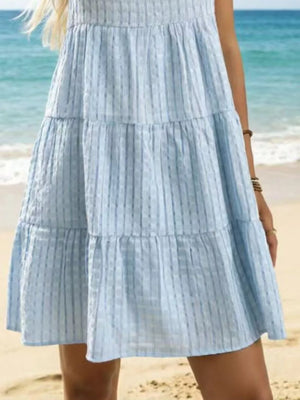 Sky blue tiered mini dress with vertical stripe texture and ruffled tiers.