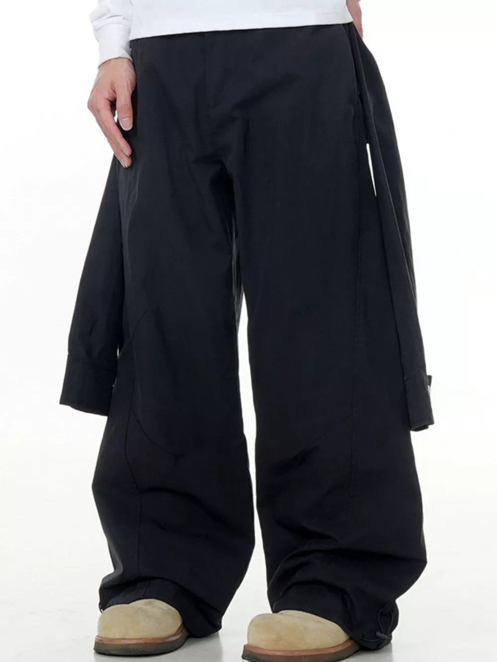 Black wide-legged cargo pants with buttoned flap pockets and drawstring hems.