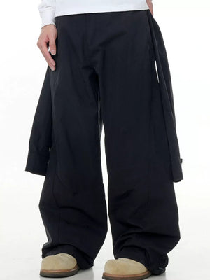 Black wide-legged cargo pants with buttoned flap pockets and drawstring hems.