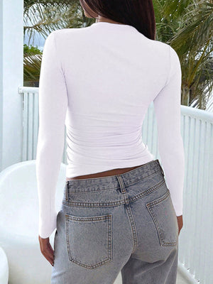 White long sleeve slim fit t-shirt with ruched sides, paired with light wash jeans.