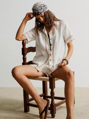 White geometric embroidered two-piece set with button-up shirt and shorts.