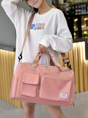 Pink Oxford cloth travel bag with multiple pockets and detachable strap.