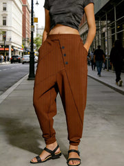 Caramel harem pants with decorative buttons and pockets, cuffed ankles.