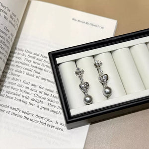 Sophisticated pearl heart drop earrings in gray with floral tops.