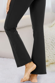Black flare-leg performance trousers with side pockets and a relaxed fit.