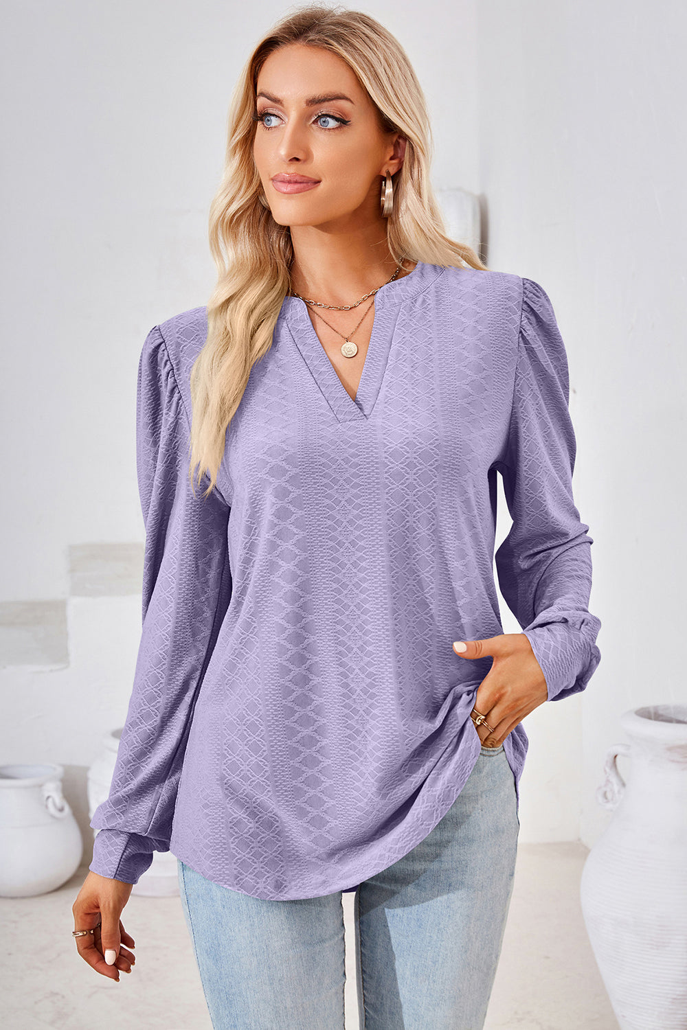 Lilac textured henley blouse with puff sleeves and a v-neckline.