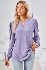Lilac textured henley blouse with puff sleeves and a v-neckline.