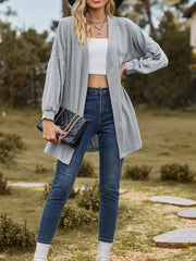 Gray textured open cardigan with balloon sleeves, worn with jeans and a white crop top.