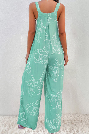 Turquoise botanical print wide-leg jumpsuit with adjustable straps and a relaxed fit.