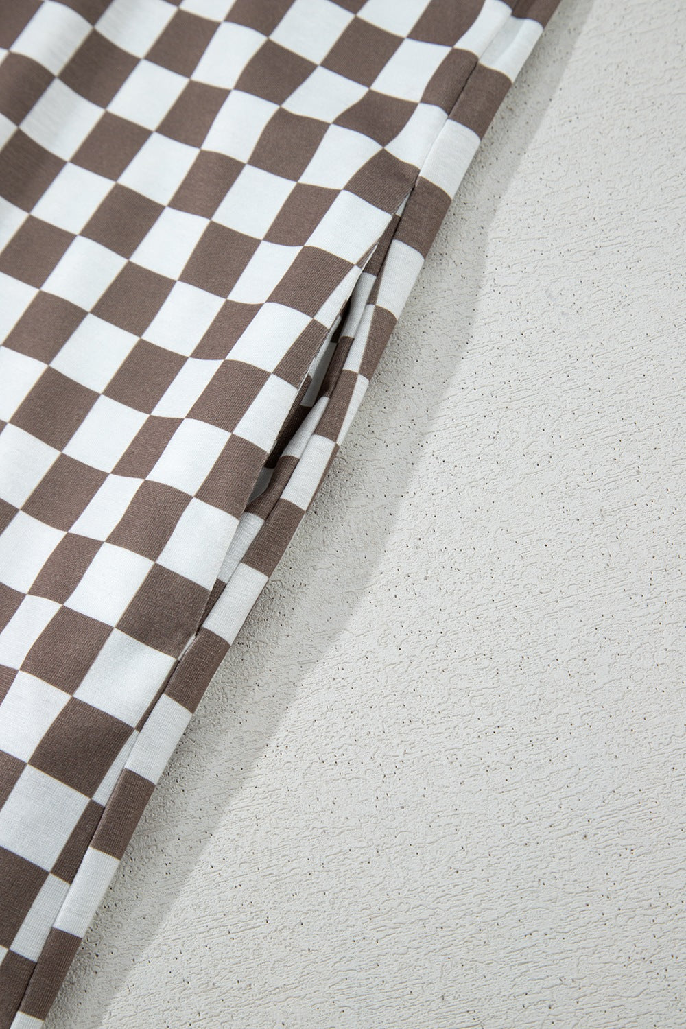Checkered palazzo jumpsuit in mocha with a visible side pocket detail.