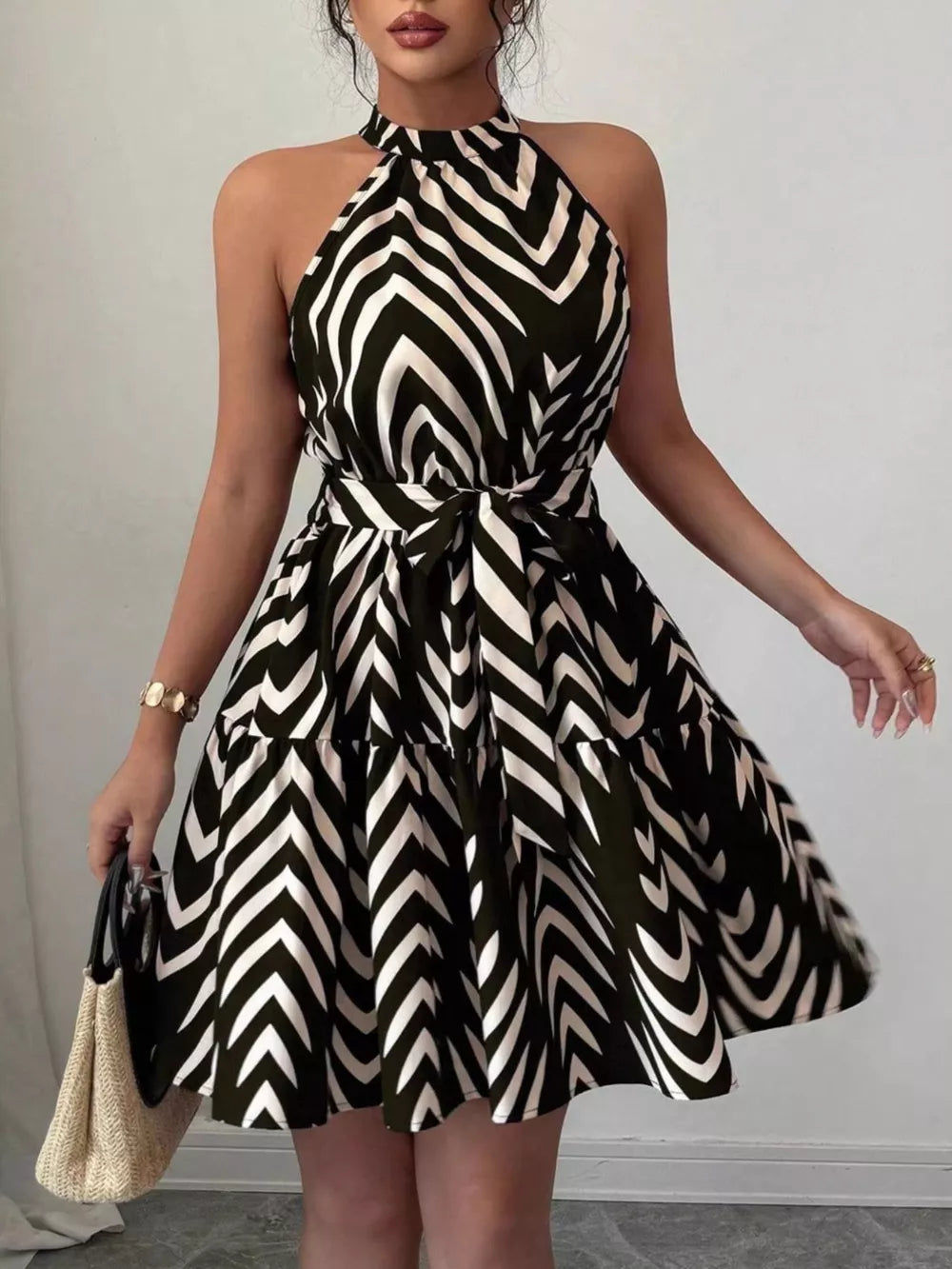 Black halter neck tie-waist ruffle dress with zebra print and tiered skirt.