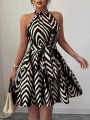 Black halter neck tie-waist ruffle dress with zebra print and tiered skirt.