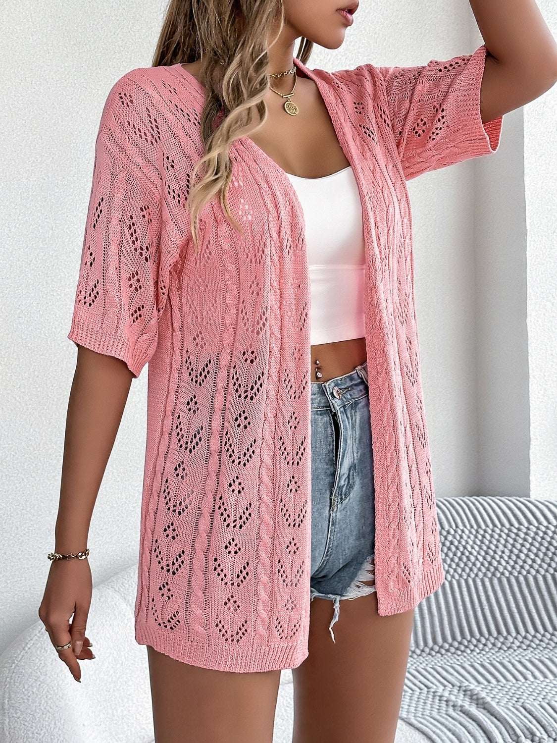 Pink open-knit pointelle cardigan with short sleeves and a V-neck.
