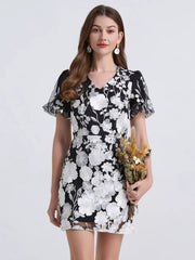 Black and white floral mini dress with puff sleeves and V-neck.