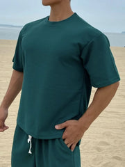Oversized deep teal cotton tee with drop shoulder and crew neck.
