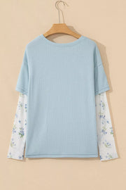 Light blue waffle knit maternity overshirt with floral print mesh sleeves.