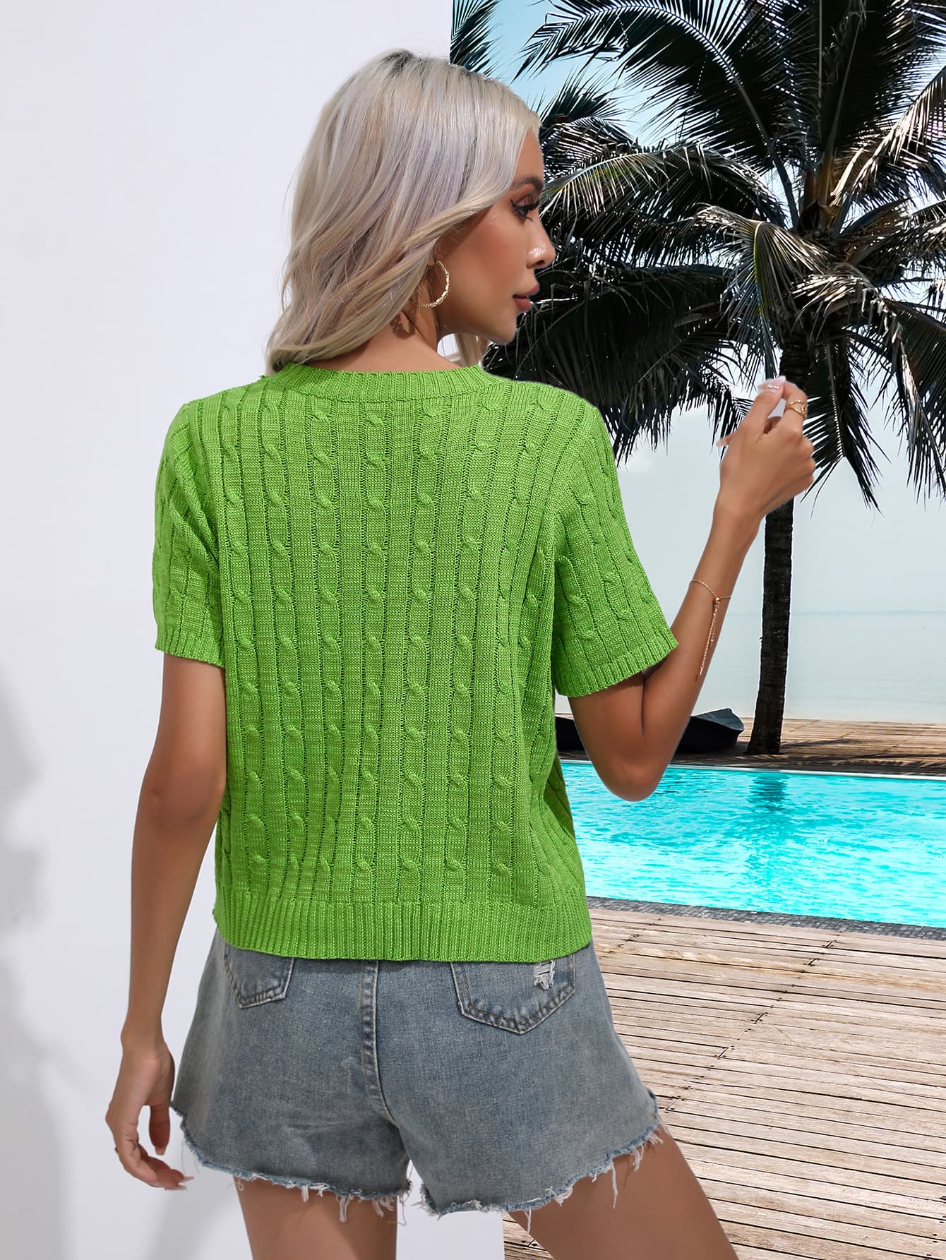 Green cable knit crew neck short sleeve sweater with detailed knit pattern.