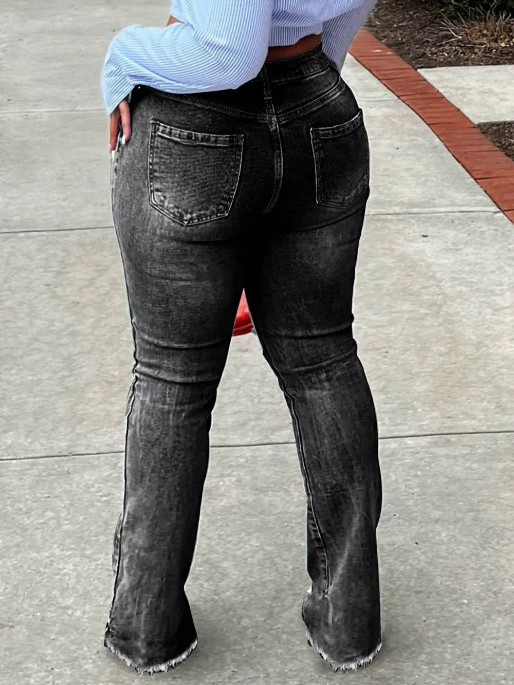 Distressed black denim flare jeans with raw hem detail