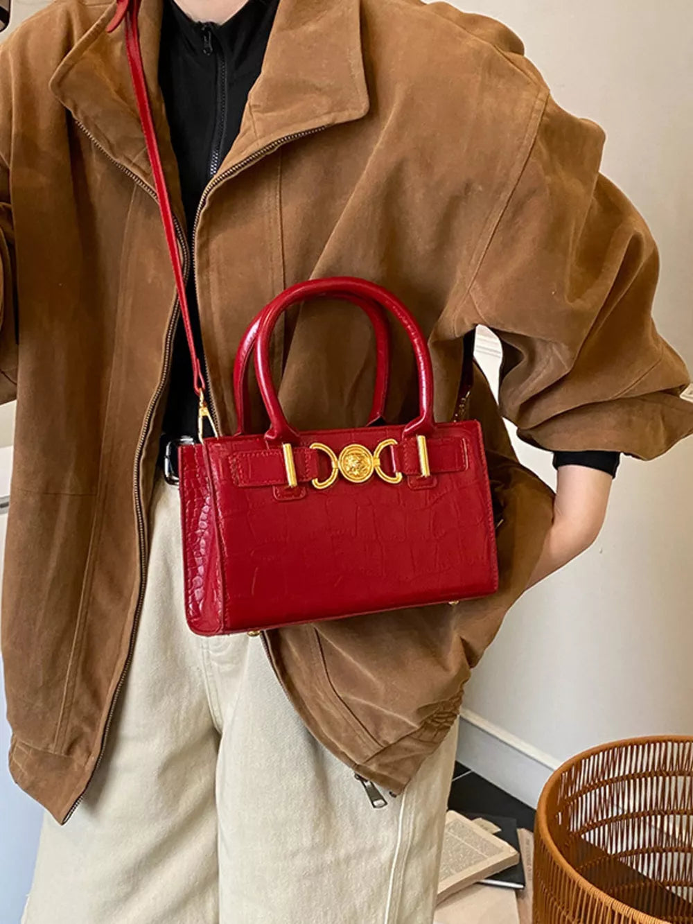 Red crocodile-textured crossbody bag with gold hardware and top handles