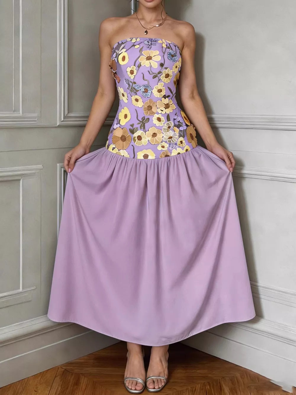 Strapless maxi dress in pink purple with floral embroidery on bodice and flowing skirt.